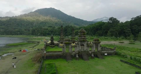 Ancient temple in Bali nestled amidst a lush landscape of greenery mountains Stock Footage 276282191