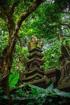 An ancient temple complex surrounded by the greenery of the Bali rainforest Stock Photos