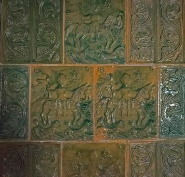 Ancient tiles with glaze and patterns on the wall. Stock Photos