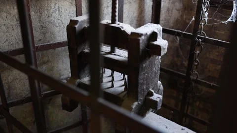 An ancient torture device with sharp spikes, surrounded by iron bars in a dark a Stock Footage 294786361