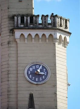 Ancient tower of light color with large round clock Stock Photos