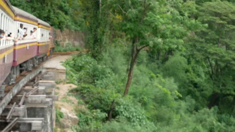 Ancient train running on a rail curving onto a bridge across the River Kwai,Thai Stock Footage 238823203