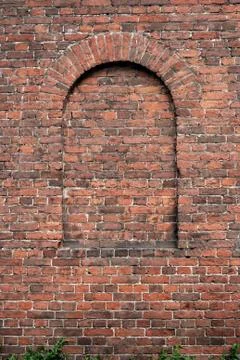 Ancient wall of brick with round false arch Foto stock