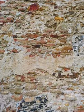 Ancient wall texture of rough natural stone, mortar and red brick fragments Stock Photos