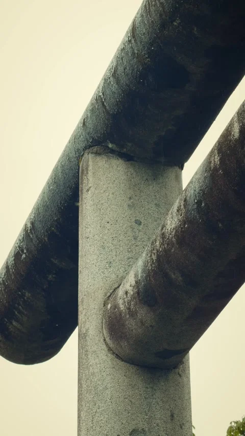 Ancient weathered stone torii gate against pale sky Stock Footage 346109956