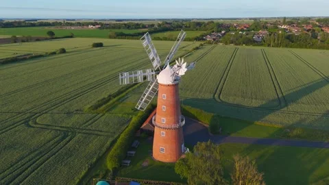 Ancient windmill stands tall amidst lush green fields Видео 342612677