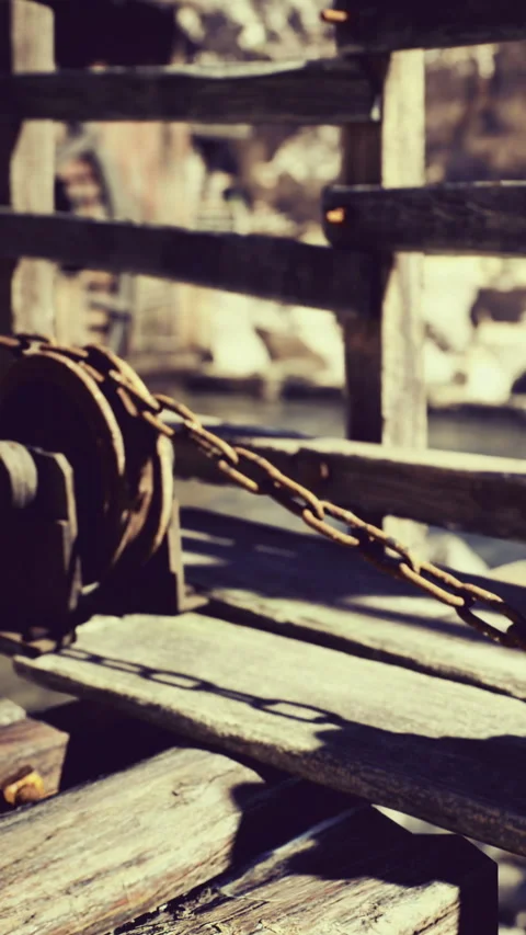 Ancient wooden pulley resting on a rustic dock under bright sunlight Stock Footage 331806990