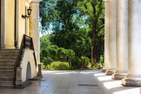 Ancient Yard with White Columns and big green Garden Stock Photos