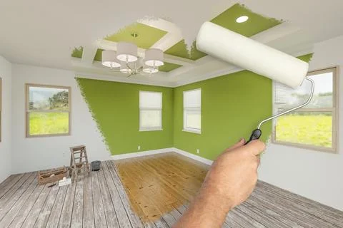 Before and After of Man Using A Paint Roller to Reveal Newly Remodeled Room.. Foto stock