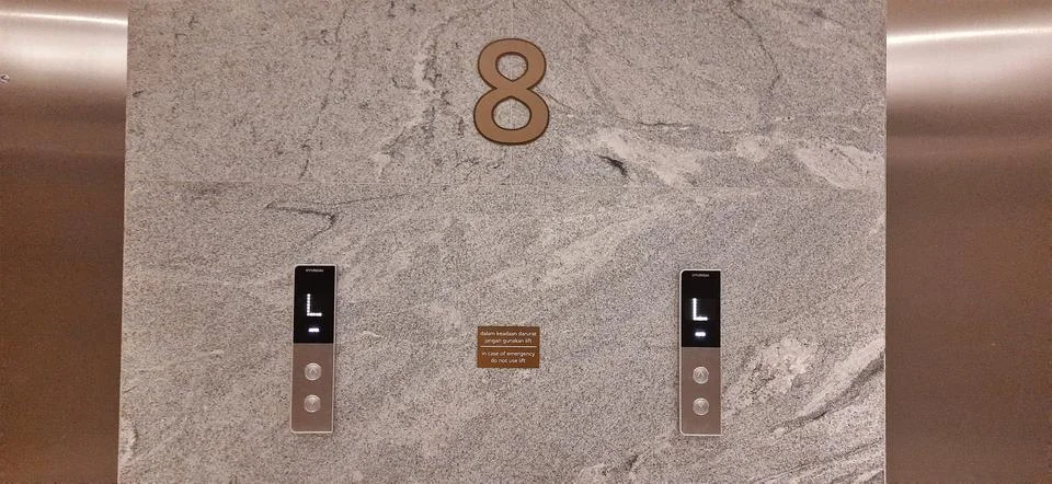 Up and down elevator buttons on the textured wall Stock Photos