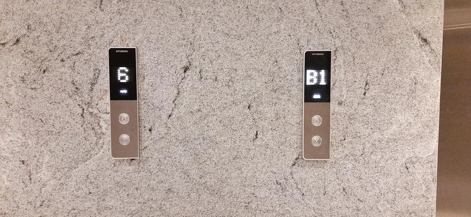 Up and down elevator buttons on the textured wall Stock Photos