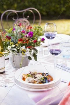 And Outdoor Table Set For Dining With A Bowl Of Mixed Shellfish In A Tomato