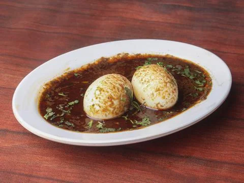 Anda Masala or Egg Curry is popular indian spicy food, served in a ceramic bo Stock Photos
