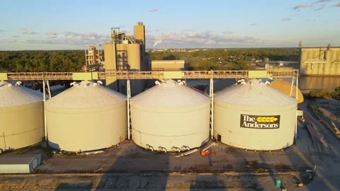 The Andersons grain silos in industrial zone on sunny evening, aerial side fly Stock Footage 304681294