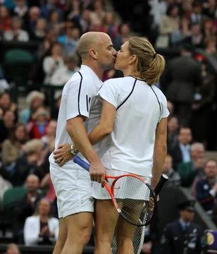 Andre Agassi And Steffi Graf Kiss At The End Of Their Mixed Doubles Game Under T Stock Photos