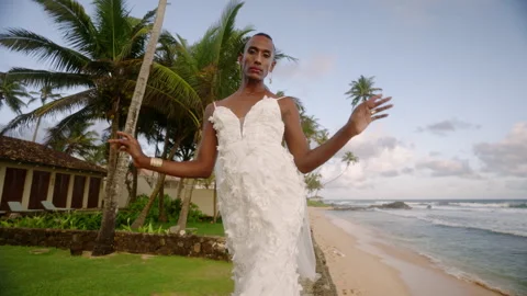 Androgynous black bride posing in wedding dress. Wind blows airy veil in air Stock Footage 273852851