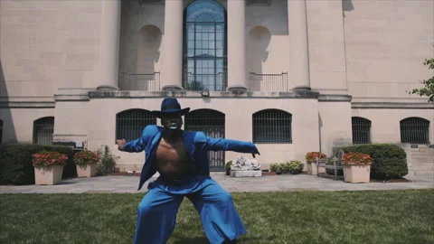 Androgynous black man voguing in a blue suit outdoors Stock Footage 331597462