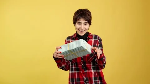 Androgynous person looking at the camera giving a present Stock Footage 236420797