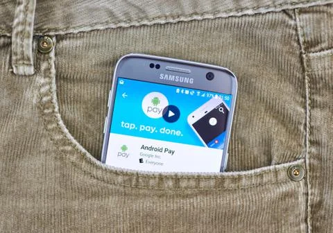 Android Pay on a cellphone screen in a jeans pocket. Stockfoto's