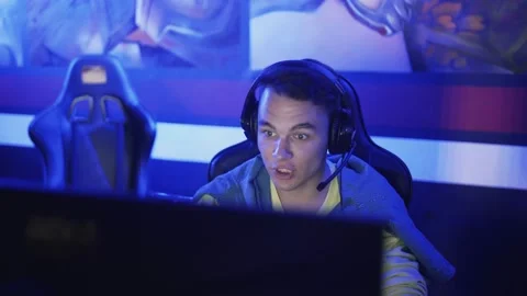 Andry man sitting at the computer at night with big headphones Video stock 136392502