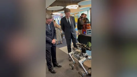 Andy Burnham and Mark Rutte watch a robotic dog dancing  Video stock 345666548