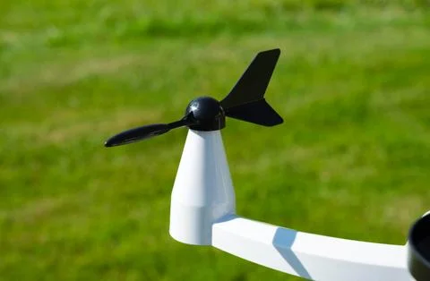 An Anemometer measuring wind direction outdoors on green grass background Stock Photos