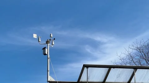 Anemometer measuring wind speed and direction on building roof Stock Footage 310081884