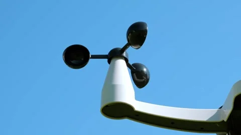 An anemometer measuring wind speed outdoors on blue sky background. Weather Stock Footage 347715236