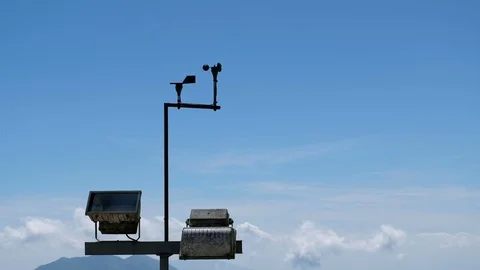 Anemometers with spotlight on blue sky, cloud and mountain background, UHD 4K Stock Footage 100417321