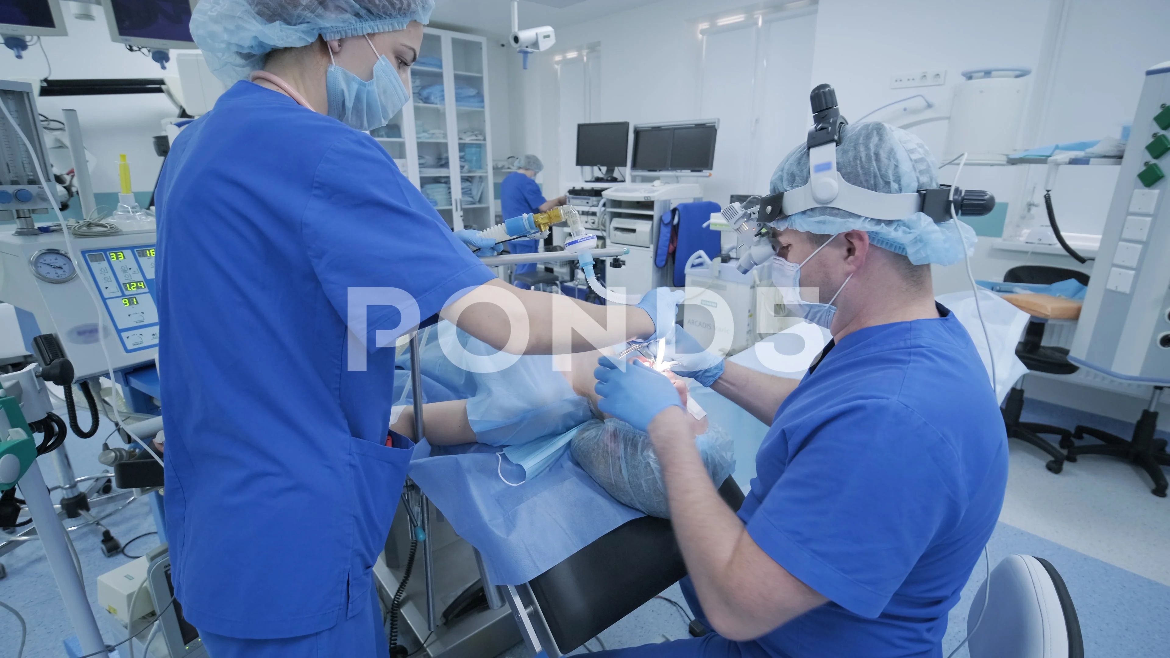 The anesthesiologist and medical team prepares female patient for surgery