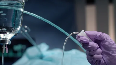 Anesthesiologist hand controlling drop counter bottle. Medical hand check drop Stock Footage 95313935