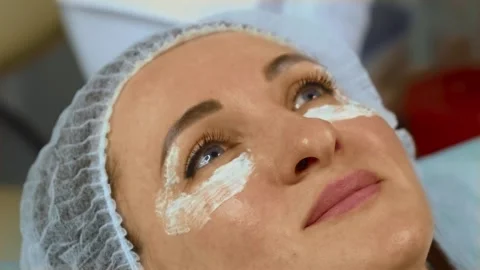 Anesthetizing cream applied under eyes of woman before facial injections Stock Footage 311819801