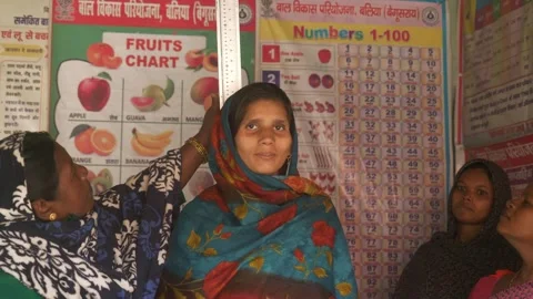 Anganwadi worker measures height of young pregnant woman to predict healthy Stock Footage 315865327