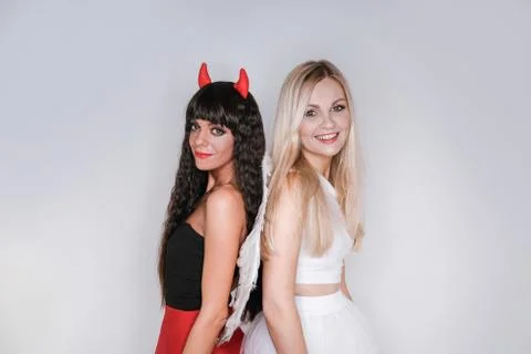 The angel and the devil stand back to back and look at the camera. Foto stock