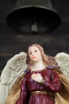 Angel Figurine with White Wings Standing Beneath Church Bell Stock Photos