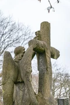 Angel statue embracing a cross Stock Photos