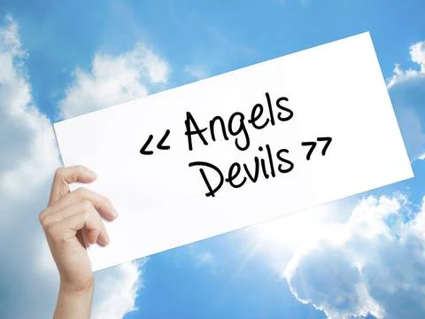 Angels - Devils Sign on white paper. Man Hand Holding Paper with text. Iso... Photos