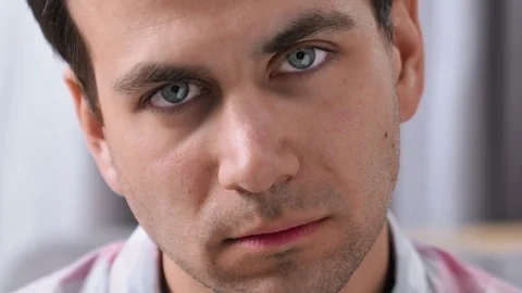 Anger man look camera close up. Displeased emotion closeup. Gloomy guy portrait. Stock Footage 253390413