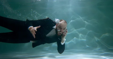 Anger management concept. Young stressed boss businessman swimming underwater Video stock 153781265