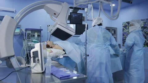 Angiographic operating: nurse helps to the three surgeons during surgery Stock Footage 45458618