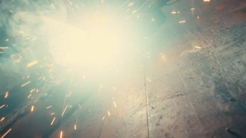 Angle grinder and welder on steel beam with sparks across wooden workbench Stock Footage 331695698