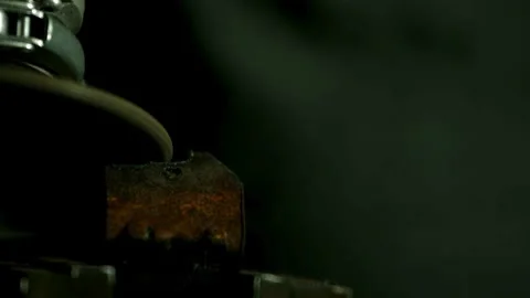 Angle grinder blade cuts metal piece held in vise Stock Footage 327514508
