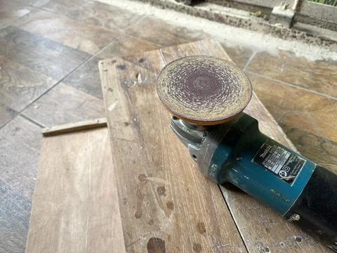 An angle grinder for cutting and grinding metal lies on wood surface Stock Photos