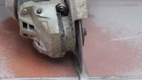 Angle grinder cutting ceramic tile floor with dust and sparks Stock Footage 345599992