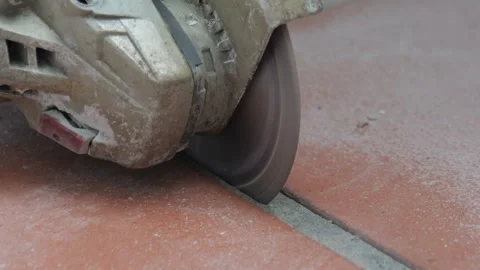 Angle grinder cutting ceramic tile with dust and motion blur Stock Footage 345600043