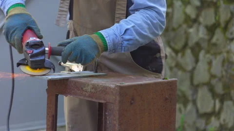 Angle Grinder Cutting Metal Plate on Rustic Workbench Stock Footage 336234283