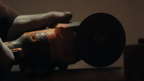 Angle grinder cutting metal sending bright sparks across workshop slow motion Stock Footage 332047801