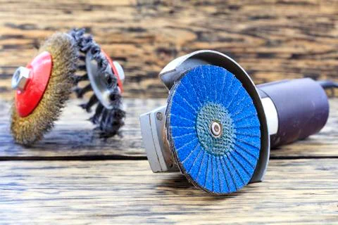 Angle grinder with grinding disc brushes lies on the background of a wooden t Foto stock