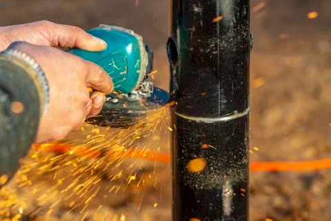 Angle grinder, pipe end. Foundation works. Locksmith. Stock Photos