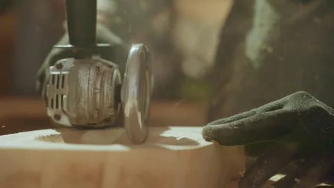Angle Grinder Shaping Wood Close Up with Gloved Hand Guidance in Workshop with Stock Footage 348120946